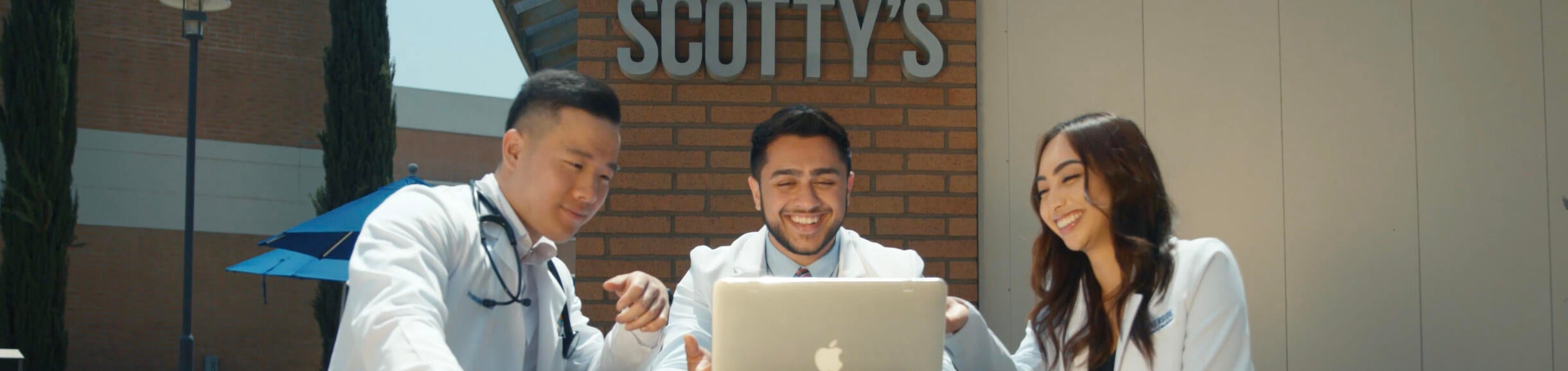 Three students looking at a computer