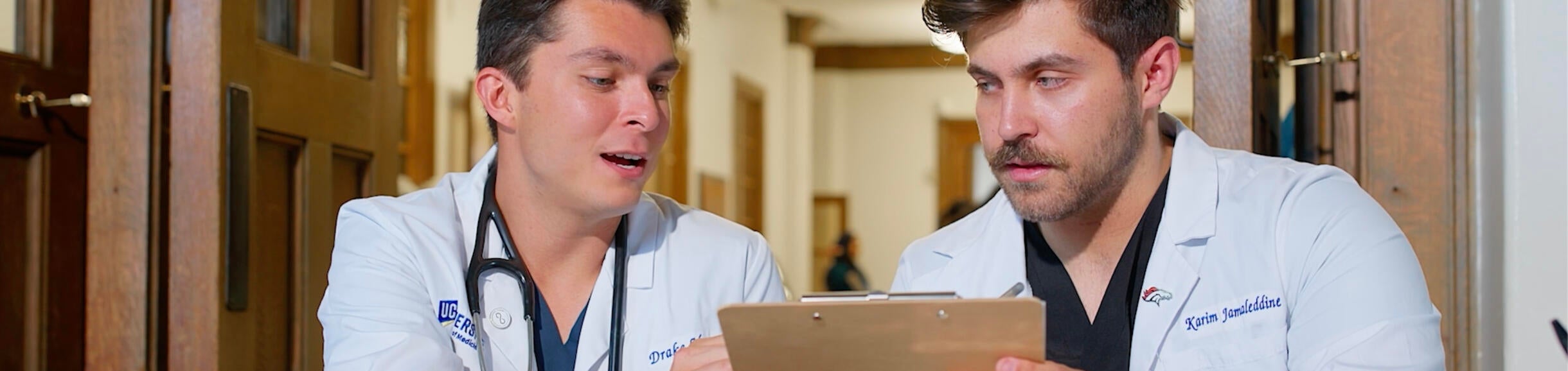 two male medical students looking at a clip board